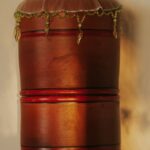 Elegant vintage wooden barrel water dispenser beside dried flowers on table.