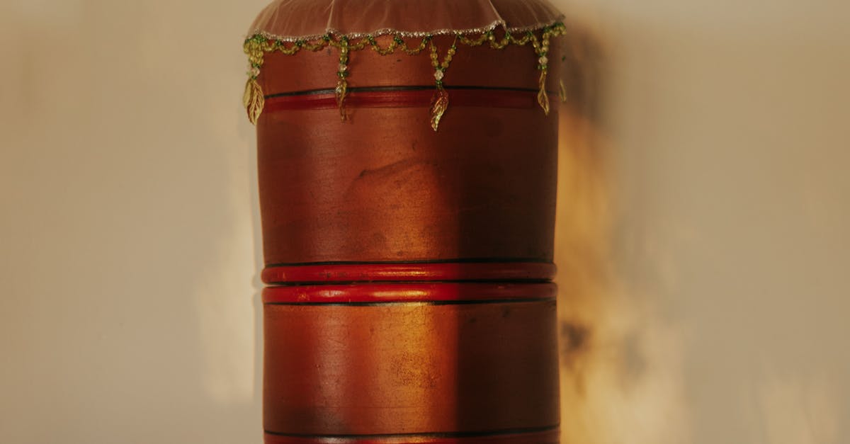 Elegant vintage wooden barrel water dispenser beside dried flowers on table.