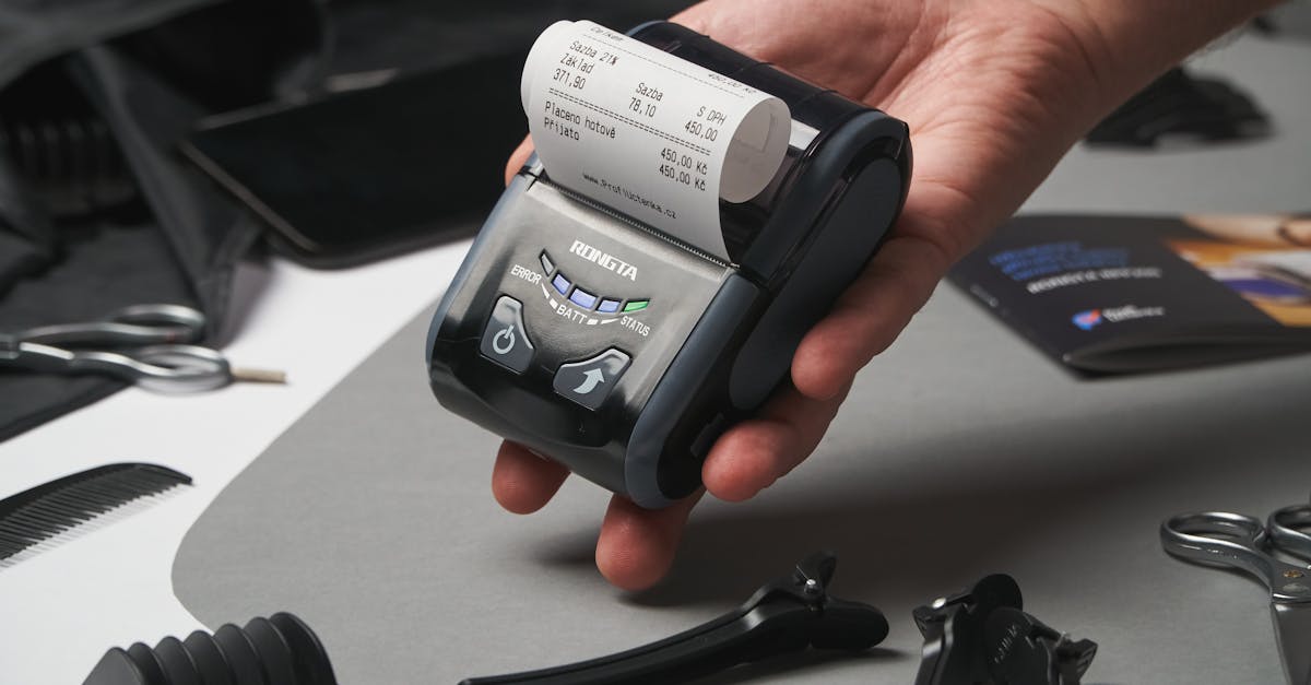 Close-up of a hand holding a digital printing device with a receipt, surrounded by grooming tools.