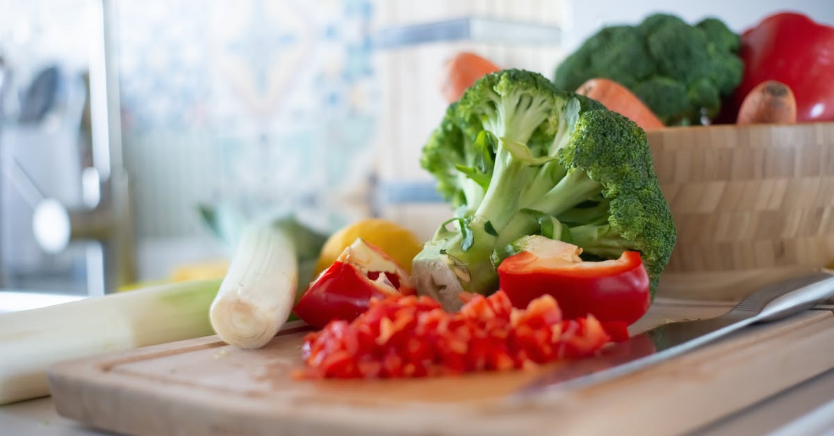 Colorful vegetables including broccoli and bell peppers on a chopping board, perfect for healthy cooking concepts.