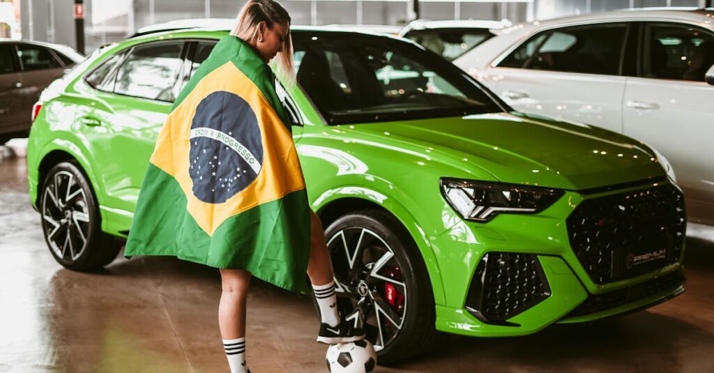 A woman draped in a Brazilian flag with a soccer ball near a green car indoors.