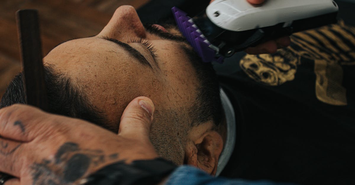 A barber skillfully shapes a beard with clippers, showcasing precision in men's grooming.