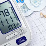 Close-up of a digital blood pressure monitor with ECG printout, pills, and medical tools.