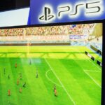 PS5 gaming console showcasing a soccer video game in a retail store setting.