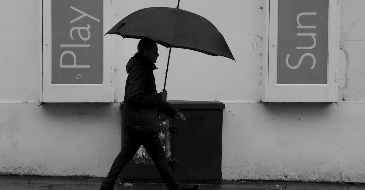A person walks with a black umbrella on a rainy day in Cheltenham, England.
