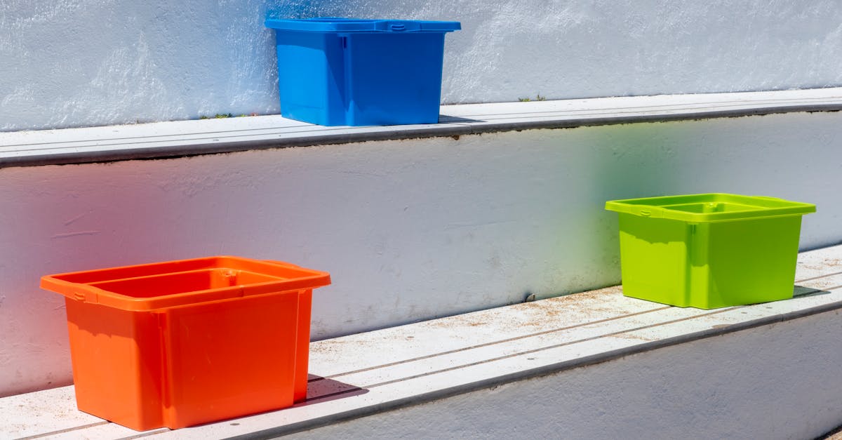 Brightly colored plastic storage boxes on outdoor steps in sunlight.