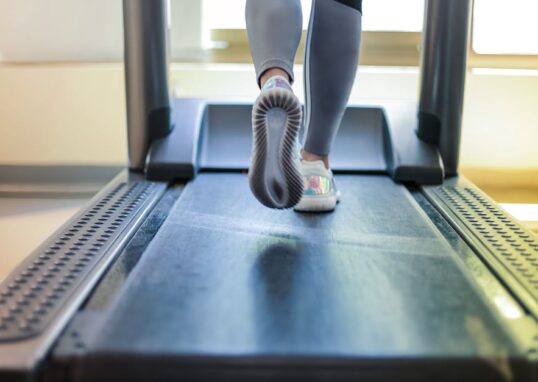 Close-up shot of a person exercising on a treadmill, showcasing fitness and health focus.