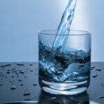 High-quality image of water being poured into a glass, illustrating hydration and purity.