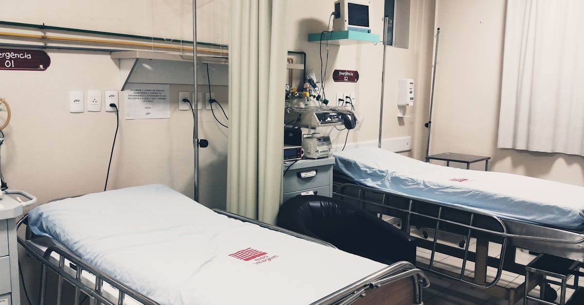 An empty hospital room equipped with two beds, monitoring equipment, and ambient lighting.