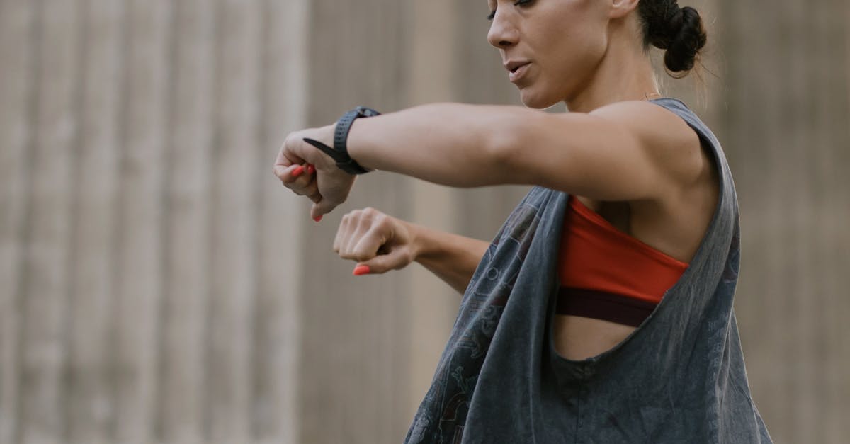 Woman in activewear checking her fitness tracker in an outdoor urban setting.