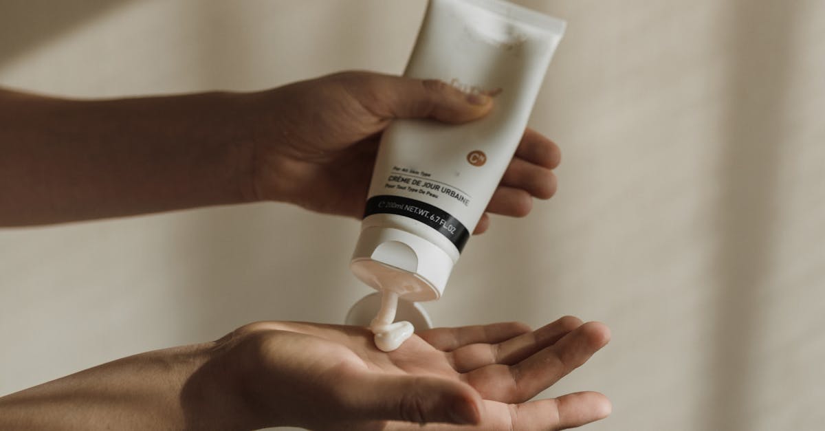 Close-up of a woman squeezing lotion onto her hand, emphasizing skincare and self-care routine.