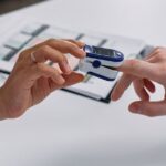 Close-up of a fingertip pulse oximeter being used to measure a patient's heart rate and oxygen levels.