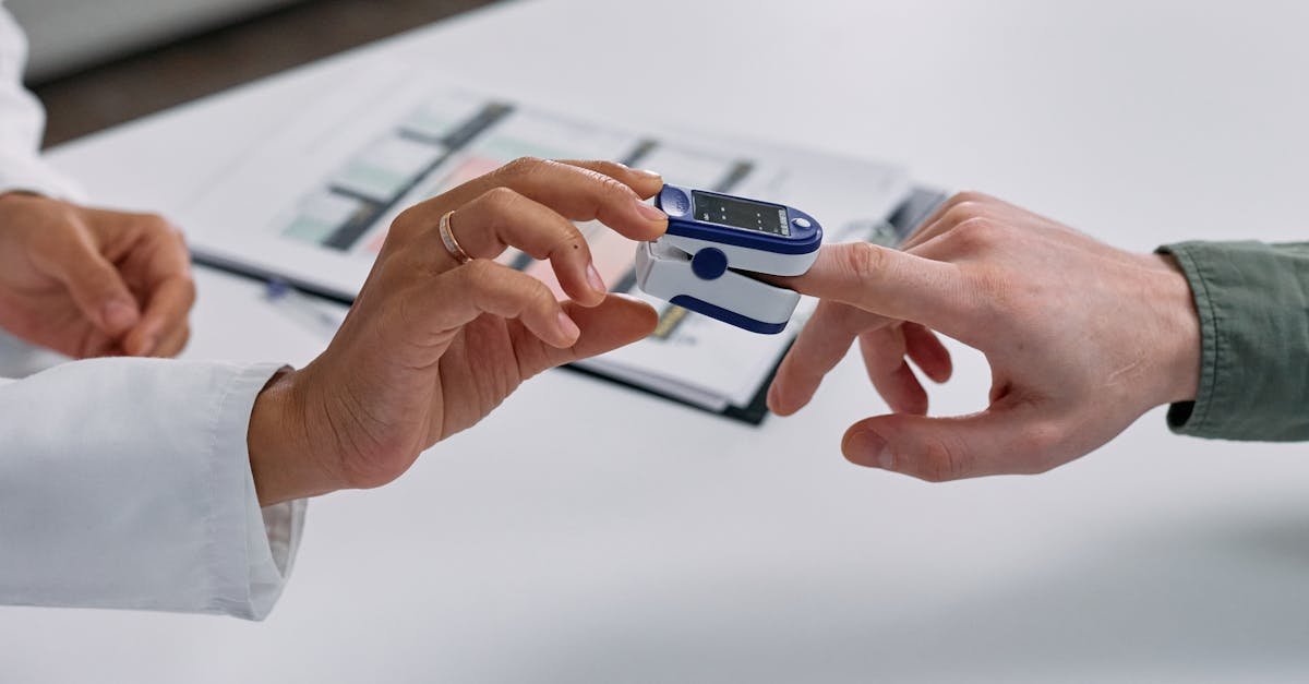 Close-up of a fingertip pulse oximeter being used to measure a patient's heart rate and oxygen levels.