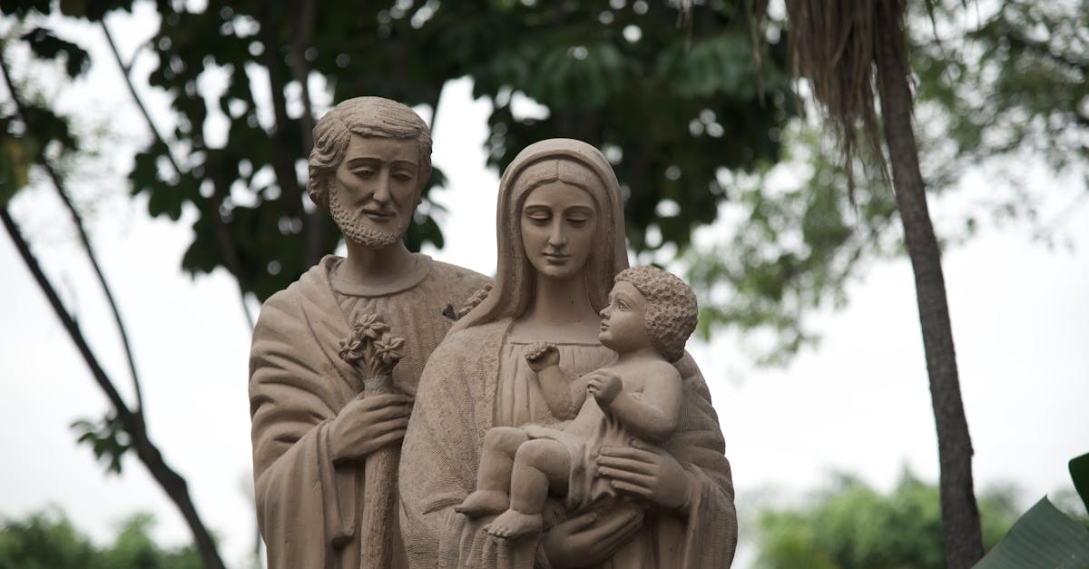 Sculpture of Saint Joseph, Virgin Mary, and Jesus outdoors.