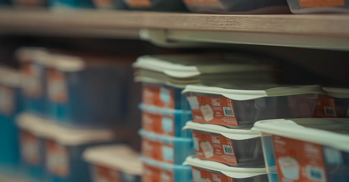 Rows of neatly stacked food containers in various colors on store shelves.