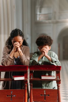 Sagrada Família de Nazaré: Um Símbolo de Amor, Fé e União para os Lares Cristãos A mother and son pray together in a church, focusing on faith and spirituality.