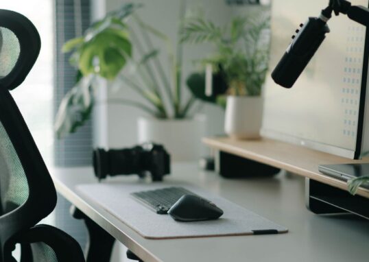 Stylish home office setup with ergonomic chair, plants, and tech accessories creating a modern work environment.