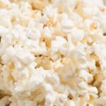 Close-up of freshly popped popcorn in a white bowl, perfect for a movie night snack.