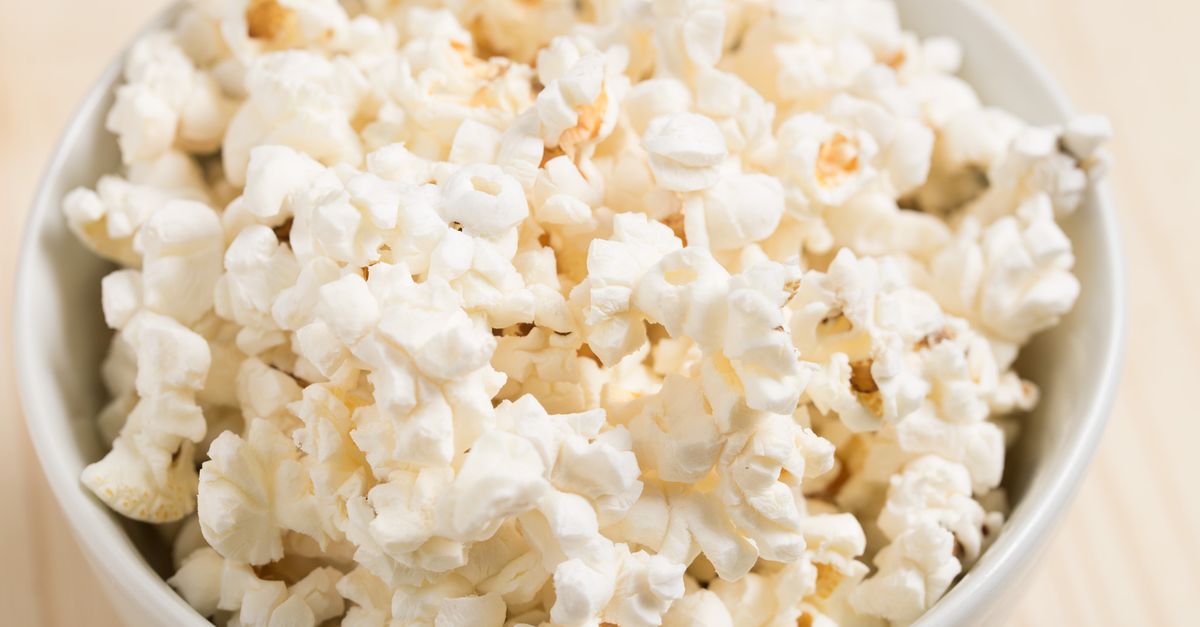 Close-up of freshly popped popcorn in a white bowl, perfect for a movie night snack.